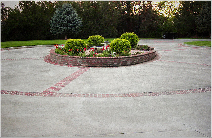 Round about circular driveway with custom brickwork with landscaping in the middle