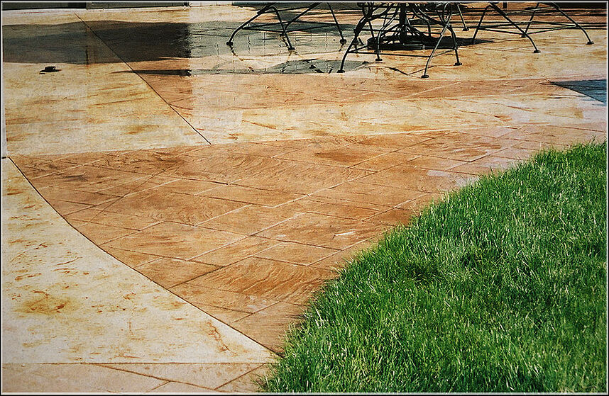 Sealed stamped and colored concrete next to grass