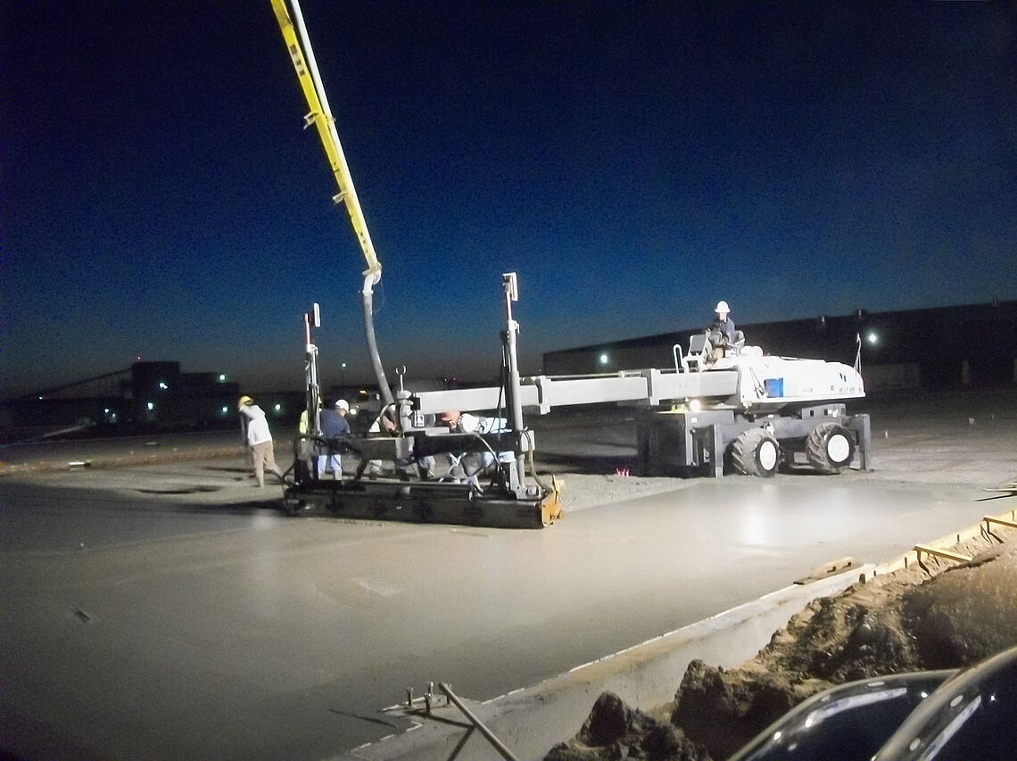 Pump truck laser screed working on a new concrete slab